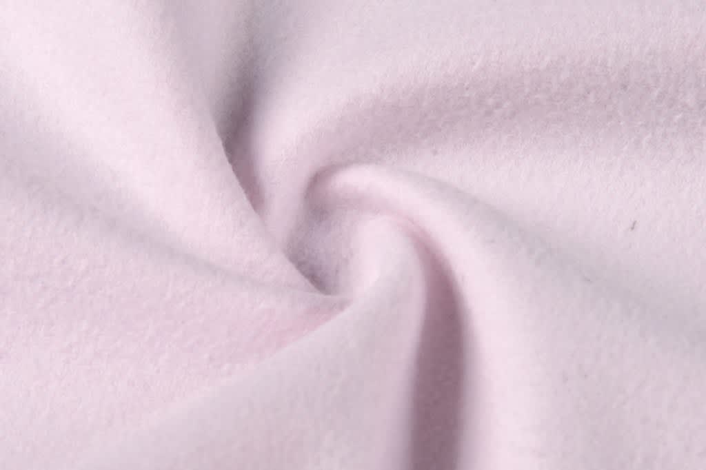 A soft, light pink fabric displaying a gentle swirl pattern, featuring a smooth texture.