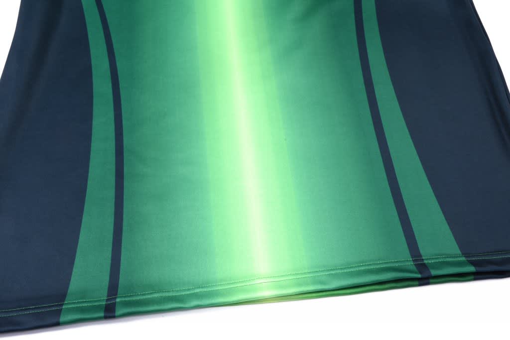A green and dark teal sublimated pullover featuring dynamic striped patterns and a logo.