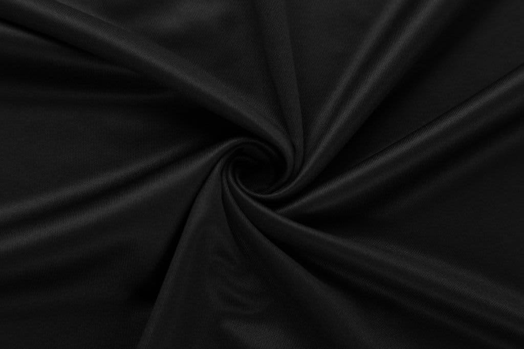 A black fabric with a smooth texture, elegantly arranged in a spiral pattern.