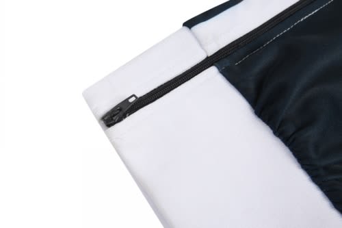 A close-up of a zipped section of a black and white fabric, featuring soft and smooth materials.
