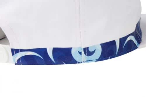 A white cap featuring a blue patterned band around the base, with an intricate design and a logo.