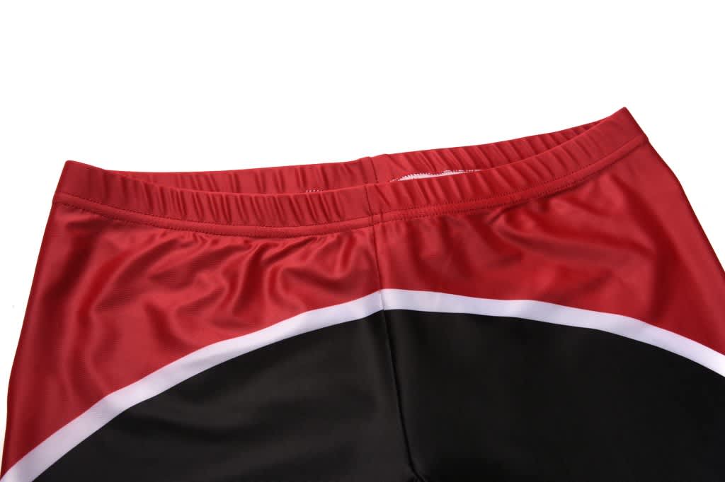 Red and black athletic shorts with a white detail, featuring an elastic waistband and a smooth fabric texture.