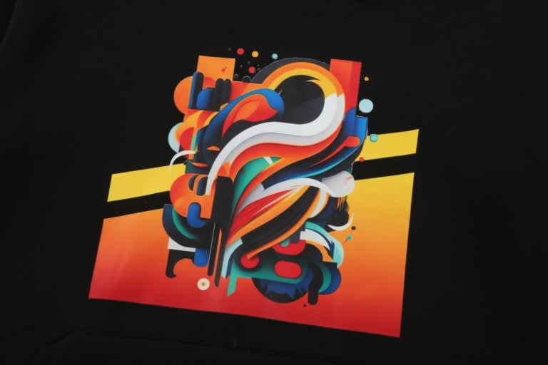 A black hoodie featuring a vibrant, abstract graphic design in orange, yellow, and blue tones with a logo.