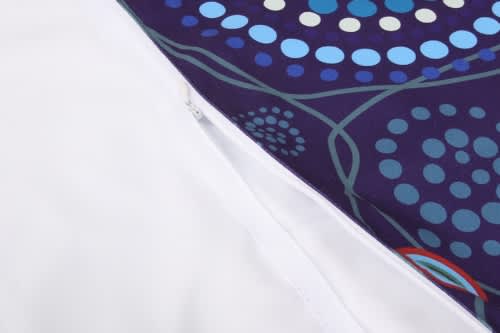 A spread towel featuring a vibrant patterned design in blue and purple, with a white backing and a zip.