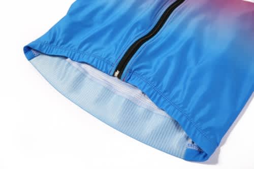 A blue sports jersey featuring a zip closure, with a gradient design. It includes a branded logo.
