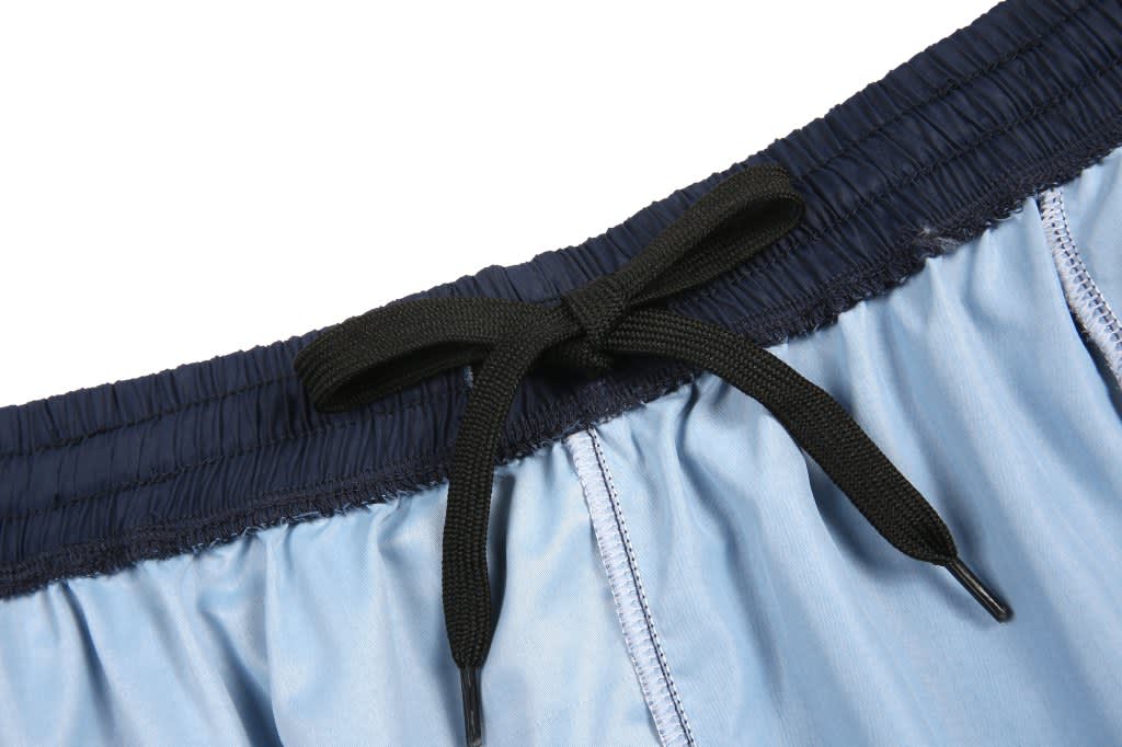 Custom woven school shorts in light blue with a black elastic waistband and drawstring. Features a logo on the waistband.