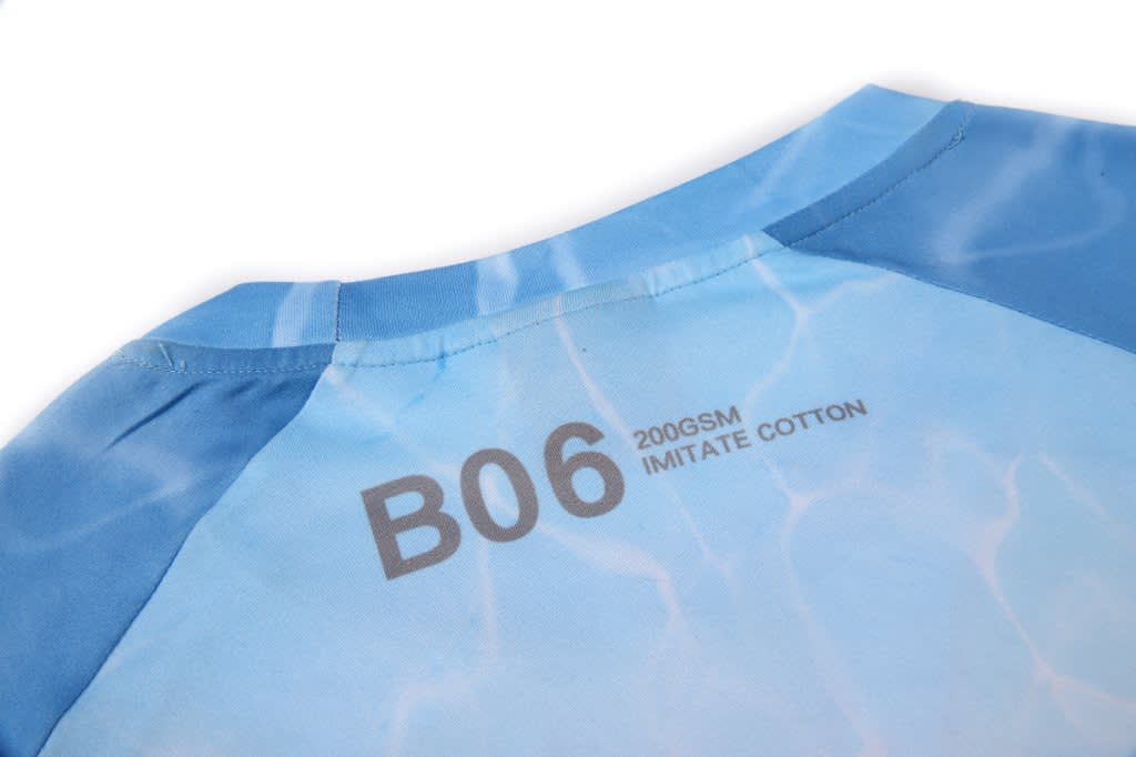 A blue women's t-shirt with a water-like design and a branding label on the back.