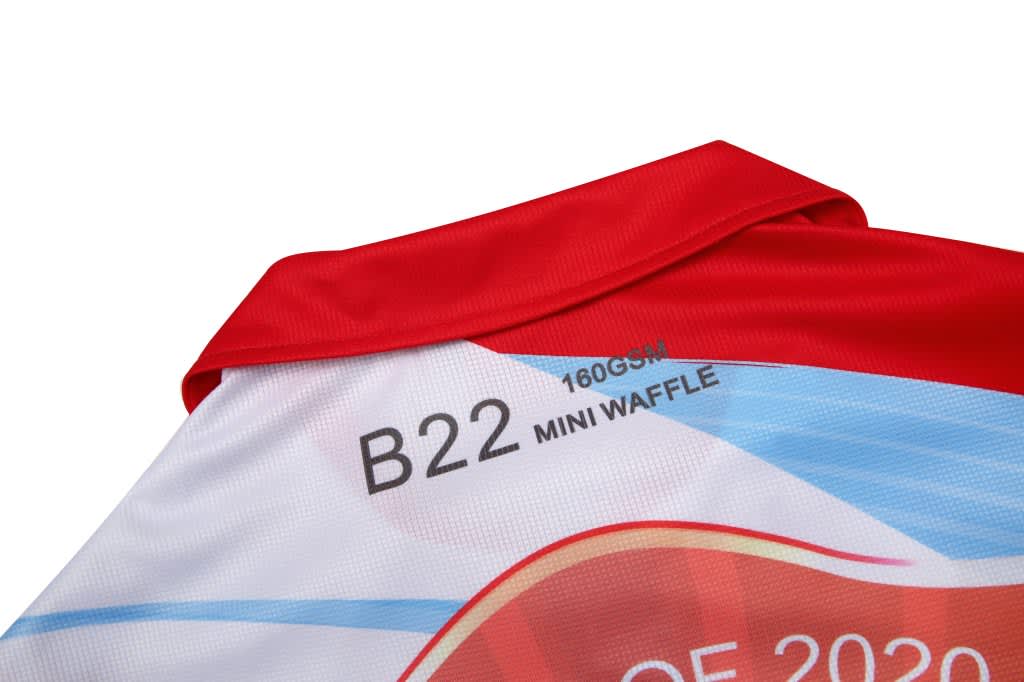 A red and white polo shirt with a collar, featuring a textured design and a logo on the back.