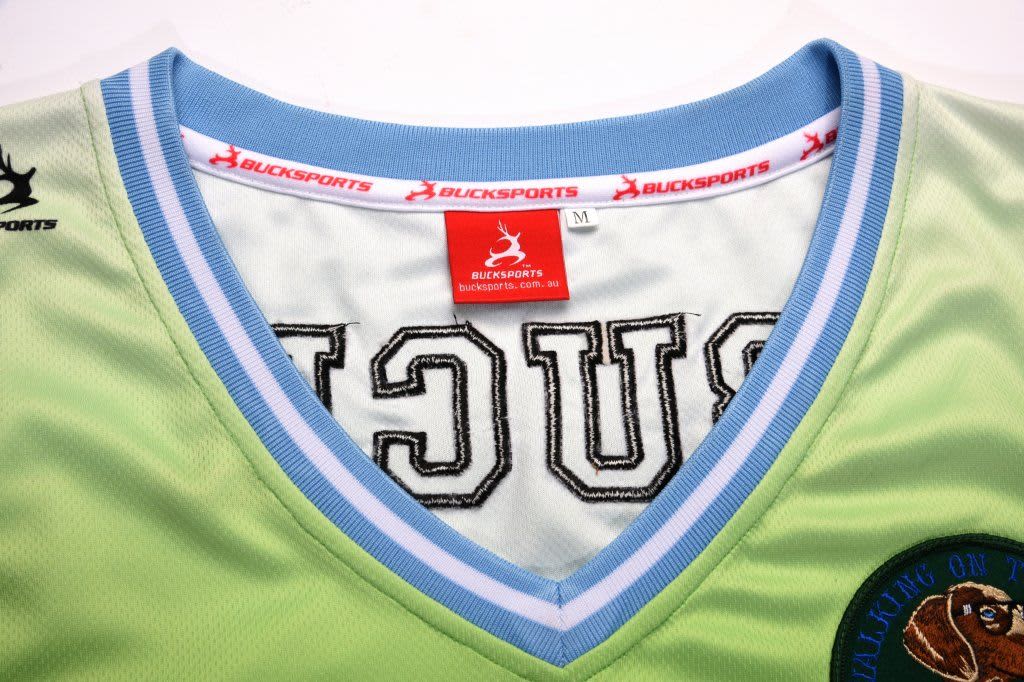 A green basketball singlet with a light blue collar and a logo on the front. It features branding inside the neck.