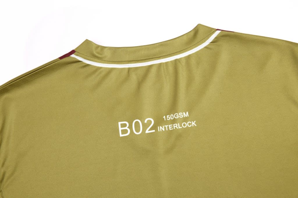 A khaki shirt featuring a white collar and a logo on the back, with red accents near the shoulders.