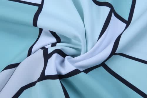 A swirling fabric in shades of light blue with a graphic pattern outlined in black.