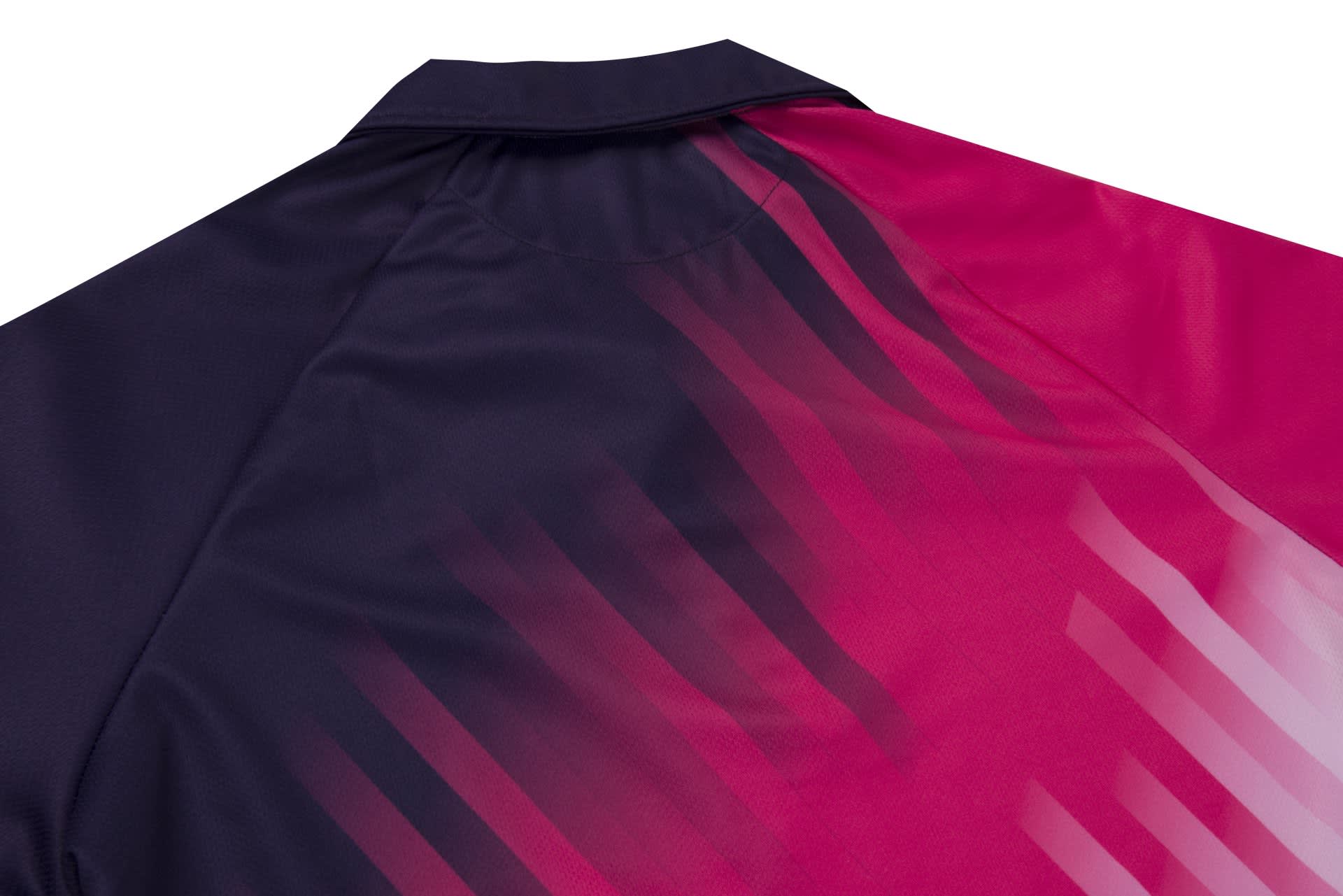 A shirt featuring a gradient design with dark navy and vibrant pink hues, complete with a logo.