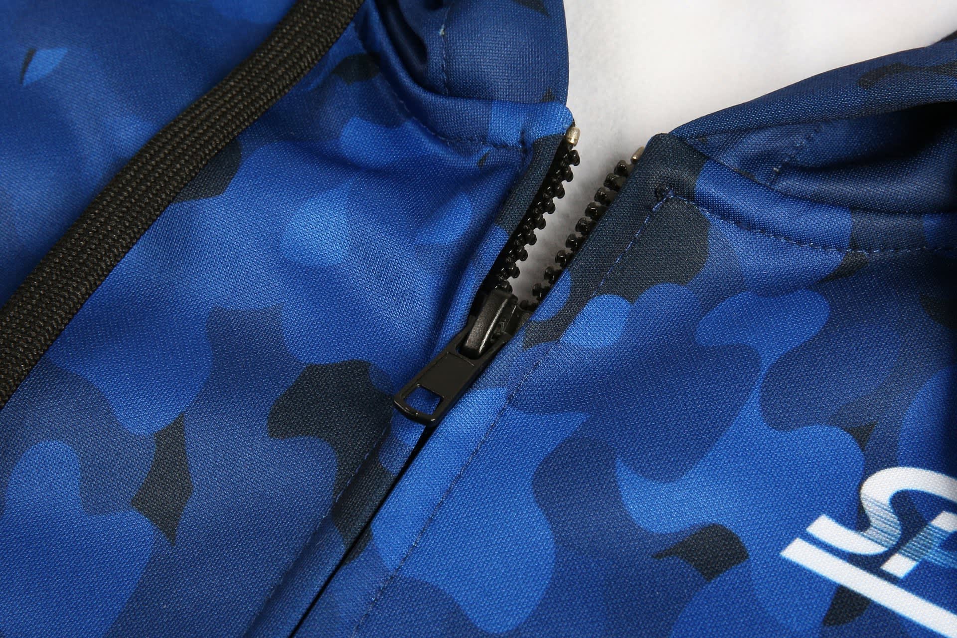 A blue camouflage hoodie featuring a zippered front closure and a logo on the side.