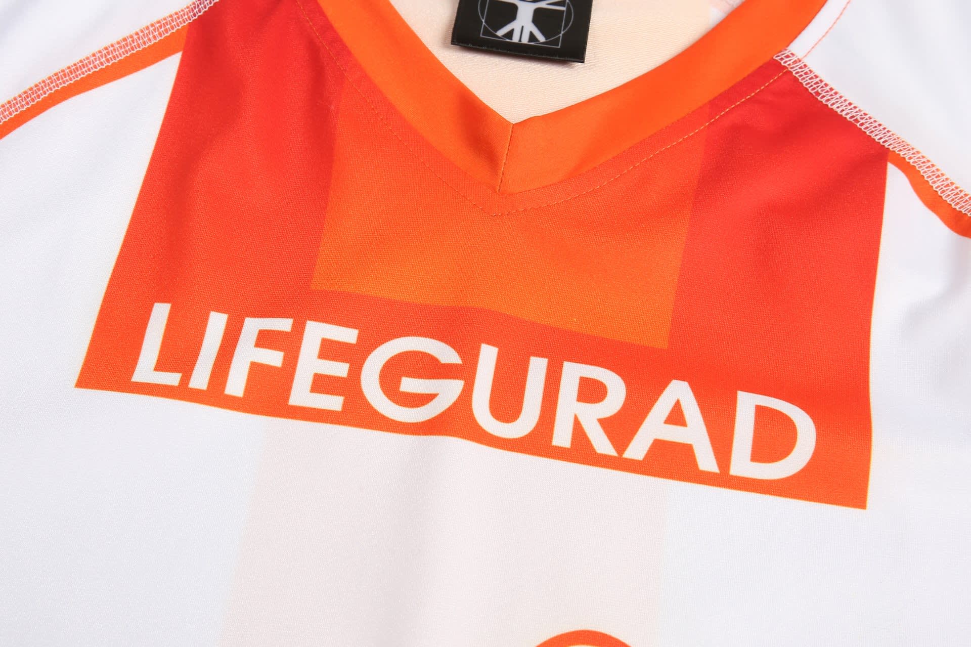 A white and orange sports uniform with "LIFEGUARD" displayed prominently on the front and a logo on the collar.
