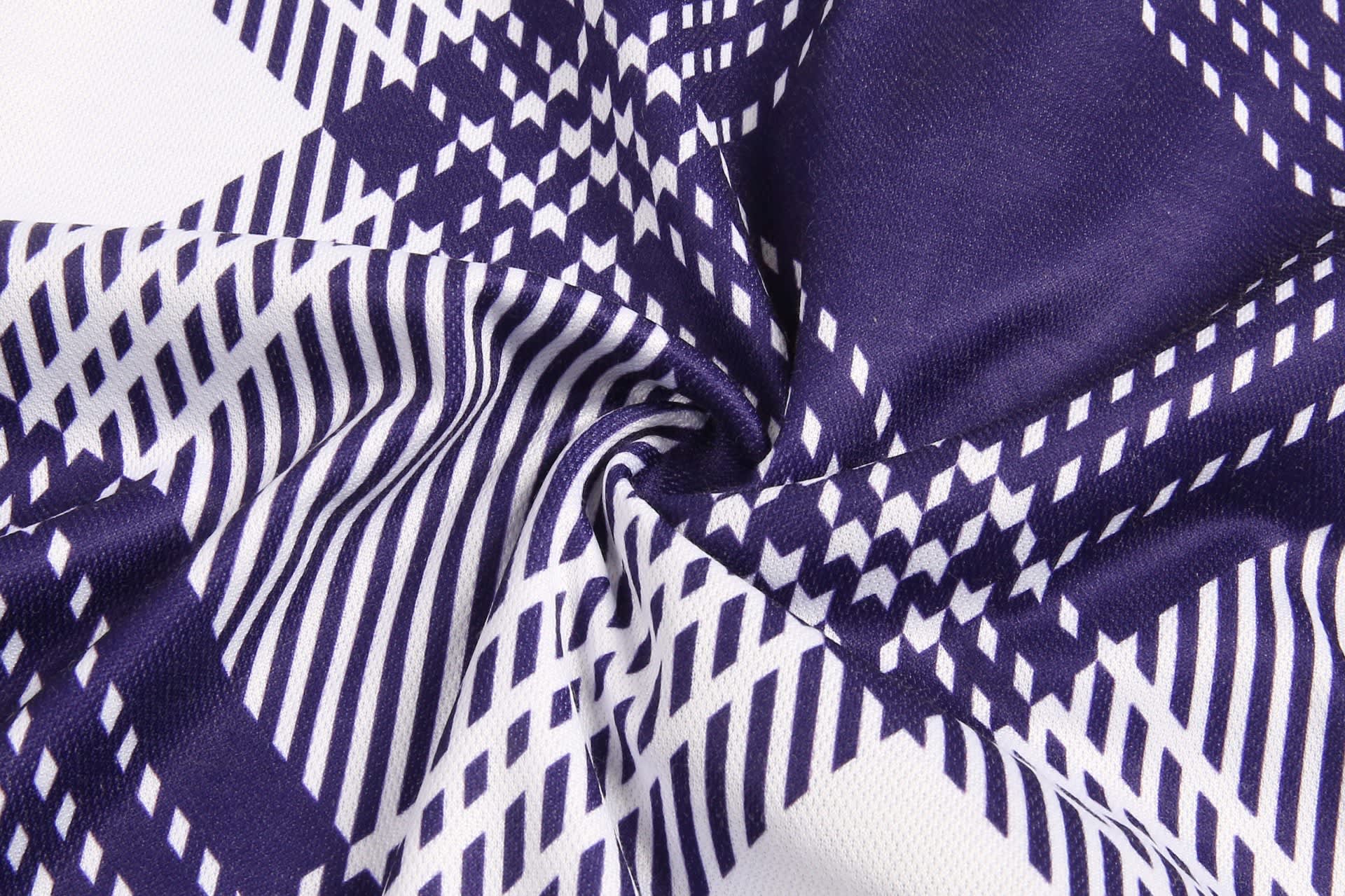 A close-up of fabric featuring a geometric pattern in navy and white. The material is soft and textured.