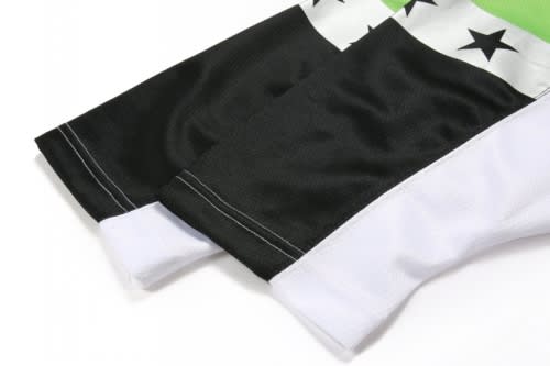 A sports uniform featuring a black, green, and white design with star patterns and sleeves. It has a logo on it.