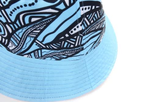 A reversible bucket hat with a blue and black abstract pattern and a wide brim. It includes a logo.