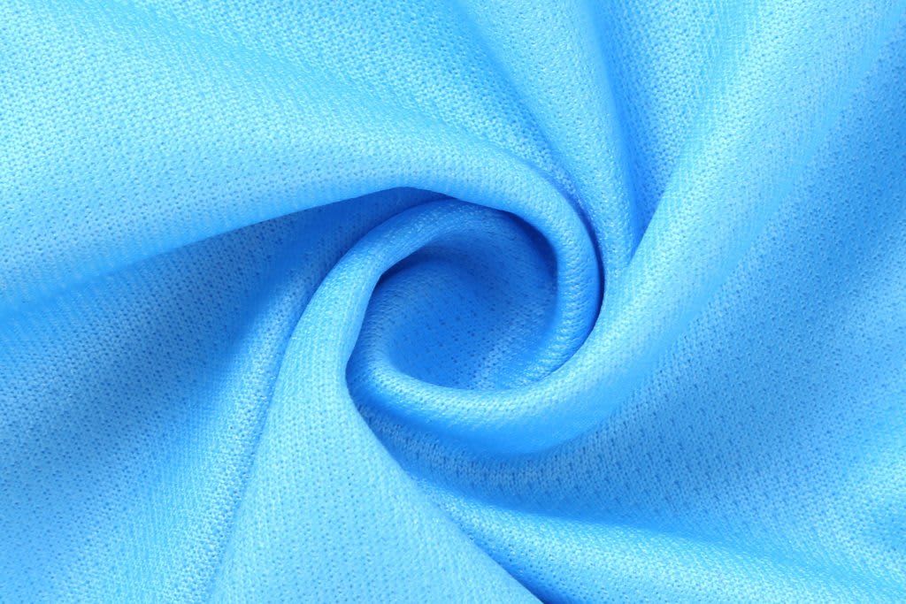 A close-up of light blue fabric, featuring a textured, swirling pattern. The material appears soft and smooth.
