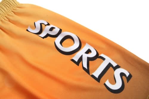 An orange sports uniform with a prominent black "SPORTS" text. It features an elastic waistband and a smooth fabric texture.