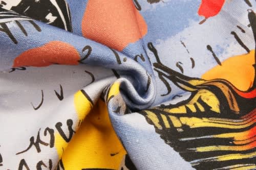 A patterned fabric with vibrant colours, featuring abstract designs in blue, yellow, red, and black.