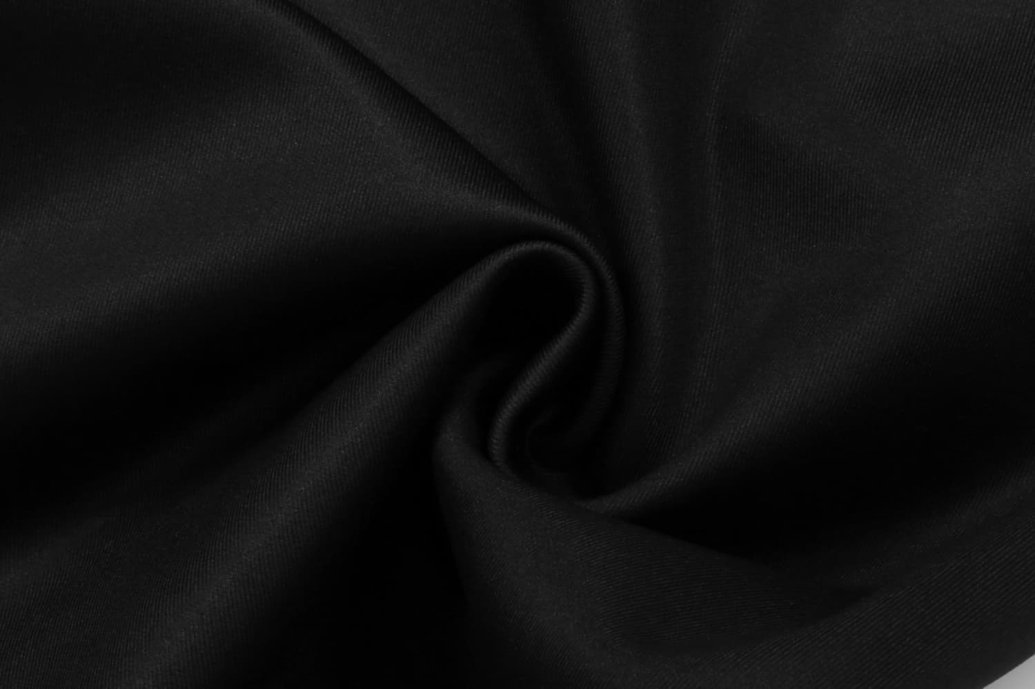 A close-up view of black fabric, showcasing a smooth texture with a spiral pattern.