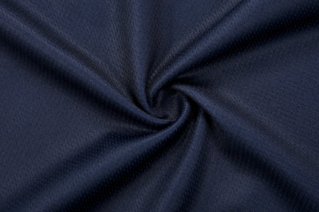 A navy fabric featuring a smooth, textured surface, ideal for a collared polo shirt design.