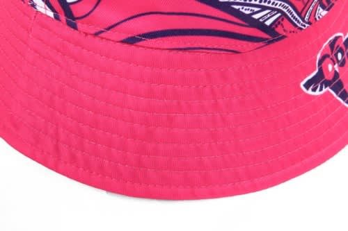 A reversible bucket hat in vibrant pink with a patterned interior and a logo on the brim.
