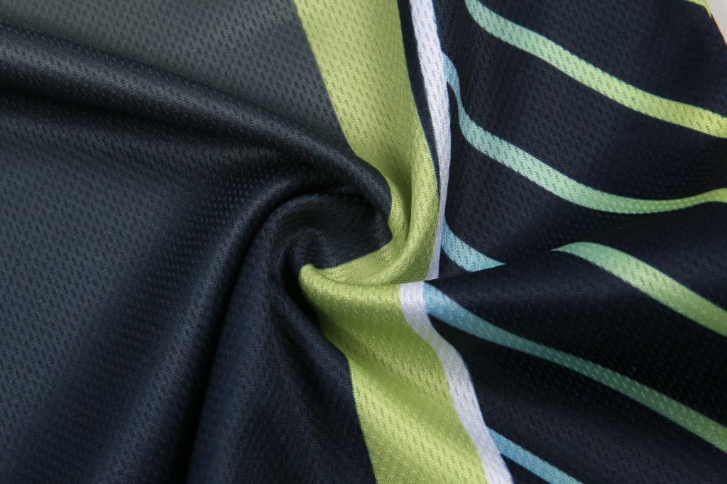 A fabric featuring a mix of dark navy blue and vibrant green with stripes, showcasing a smooth texture.