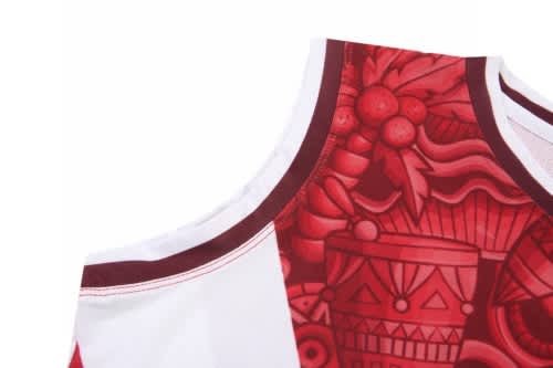 A basketball uniform featuring a red and white design with intricate patterns and a logo on the fabric.
