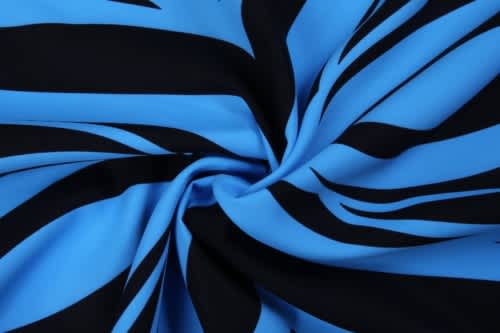 A swirl of fabric featuring bold blue and black stripes, showcasing a smooth, stretchy texture.
