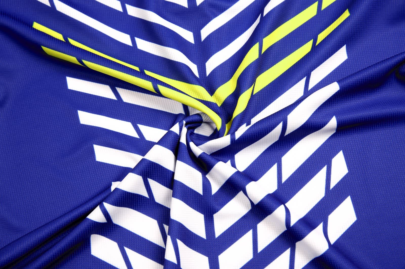 A blue polo shirt with a zigzag pattern in white and bright yellow, featuring a logo.