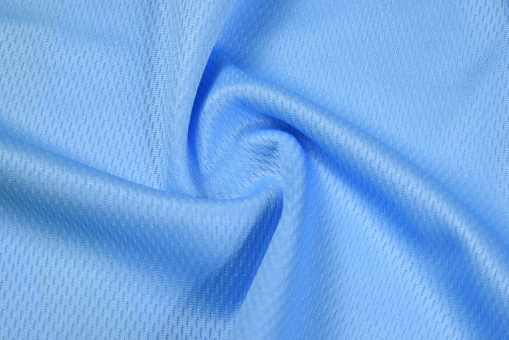 A light blue fabric with a textured pattern, featuring a swirling design. The material appears soft and lightweight.