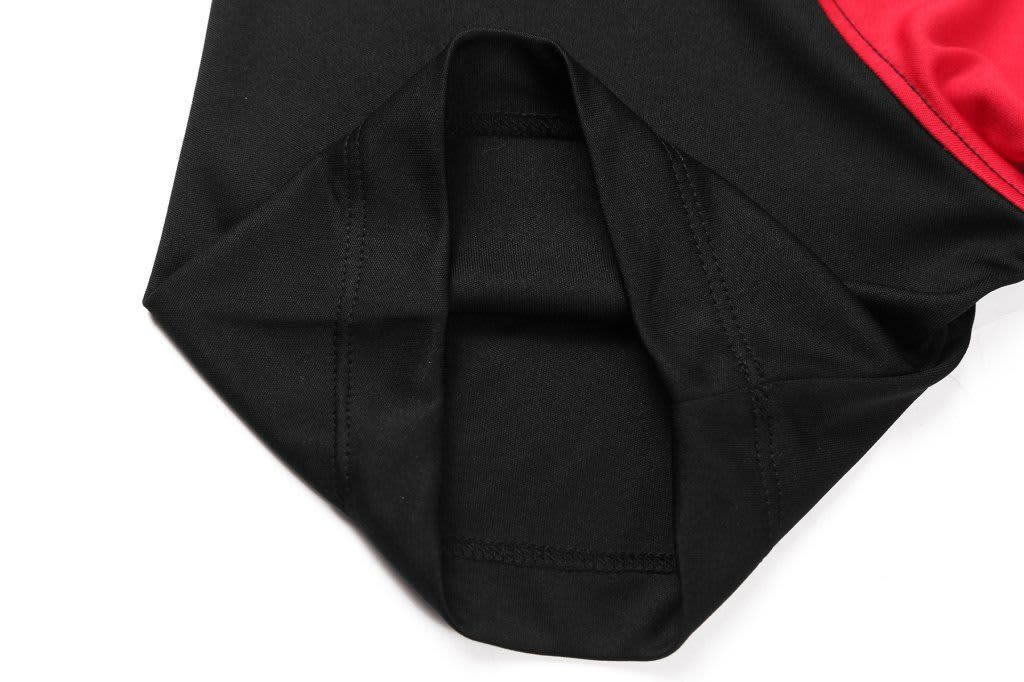 A black and red garment featuring a cut-and-sew design with a rounded hem and stitched detailing.