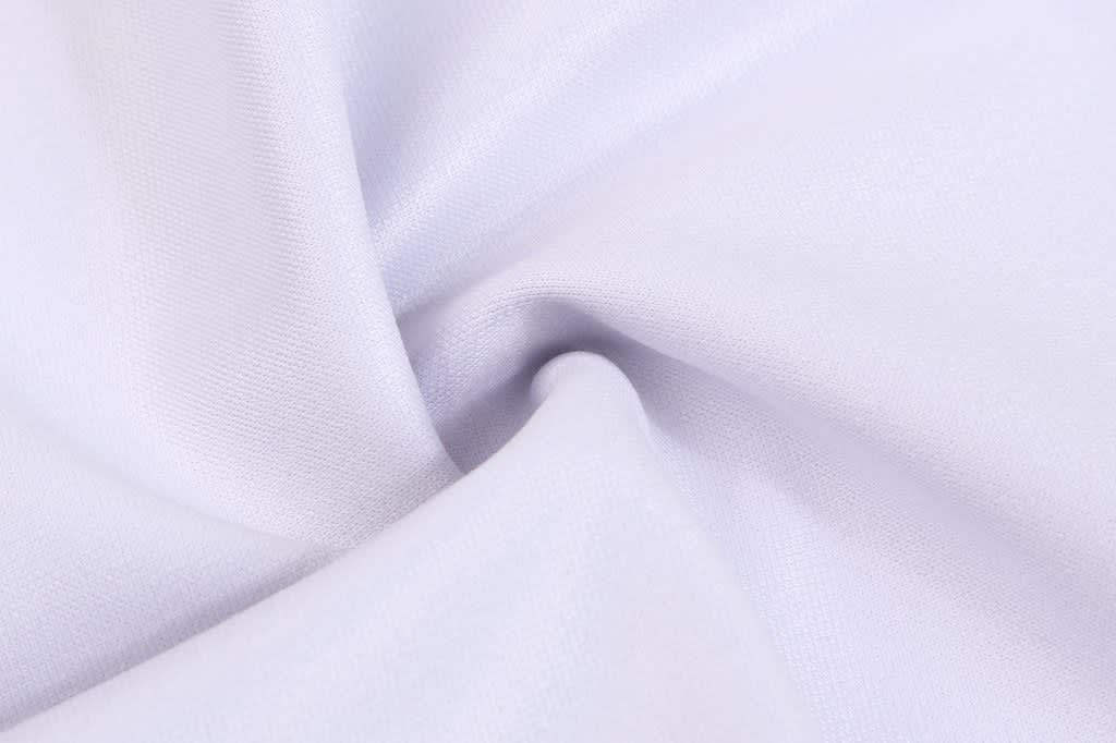 A white fabric showcasing a smooth texture, suitable for clothing or sportswear. The material appears lightweight and breathable.