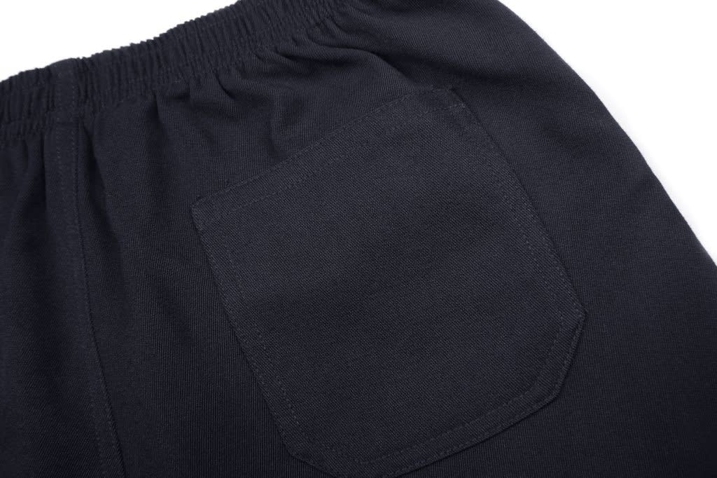 A close-up of black shorts featuring an elastic waistband and a back pocket. The fabric appears smooth and sturdy.