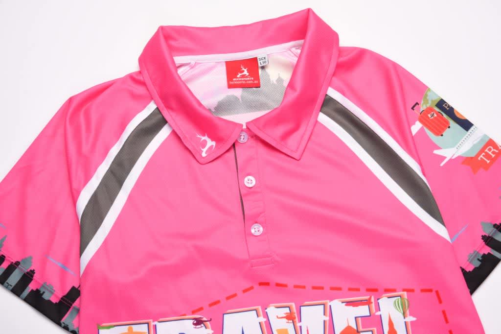 A pink sublimated polo shirt with a collar and a branded label, featuring various design elements.