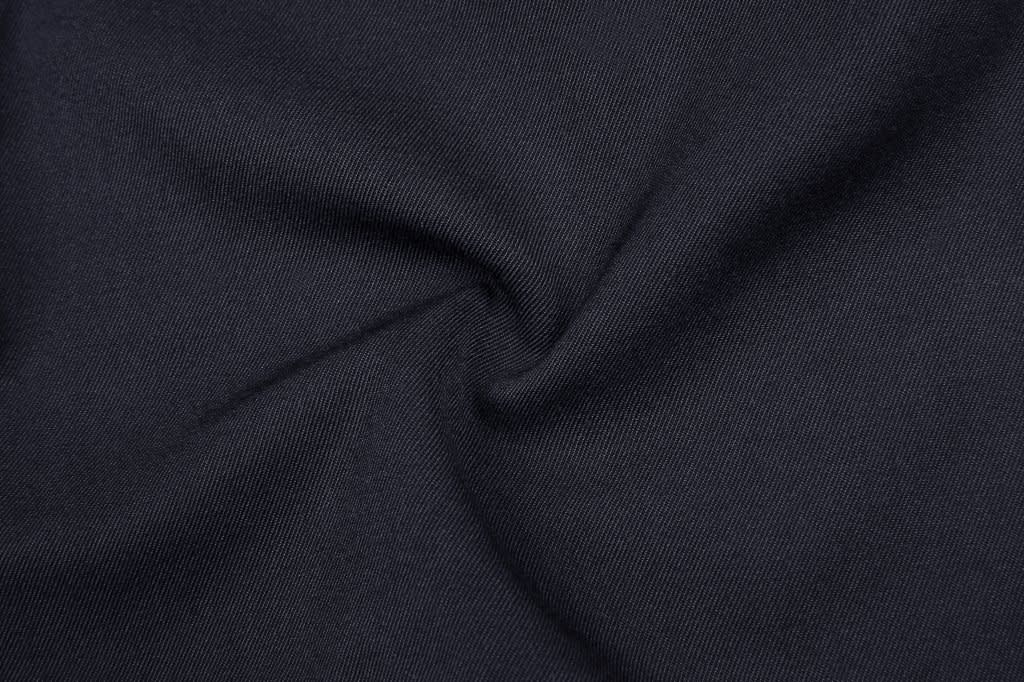 A close-up of black fabric with a swirling texture, showcasing a smooth and versatile material.