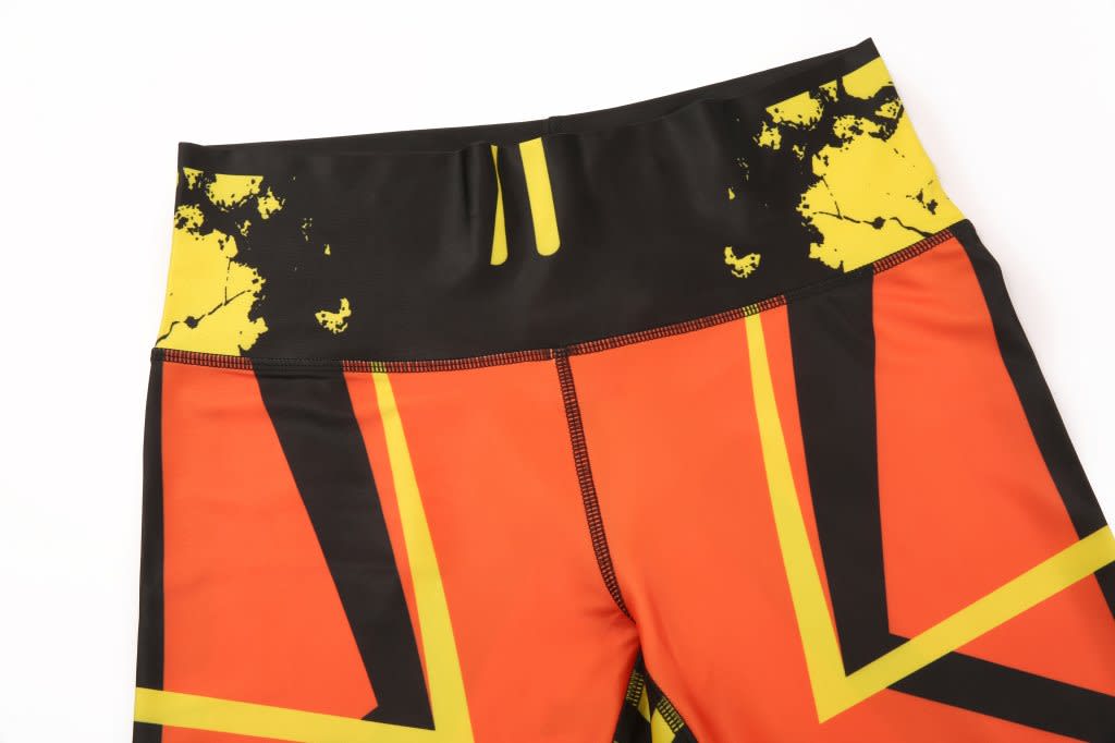 A pair of custom-made leggings featuring a bold design with orange, black, and yellow patterns.