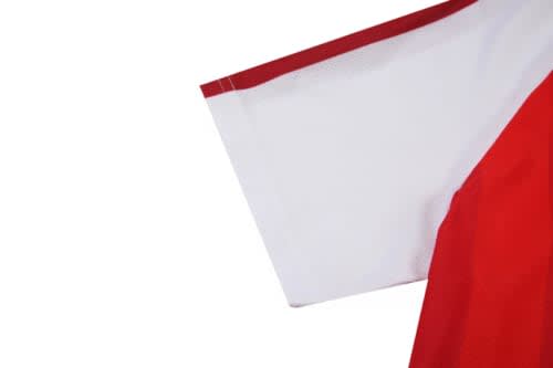 A red and white soccer uniform jersey featuring a logo, highlighting the sleeve design.