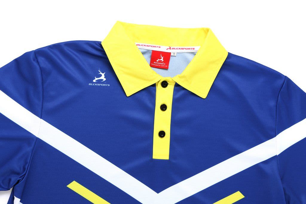 A blue cricket polo shirt with yellow collar and white accents, featuring a logo on the chest.