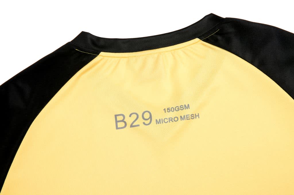 A custom design team T-shirt in yellow and black with a label displaying fabric details and a logo.