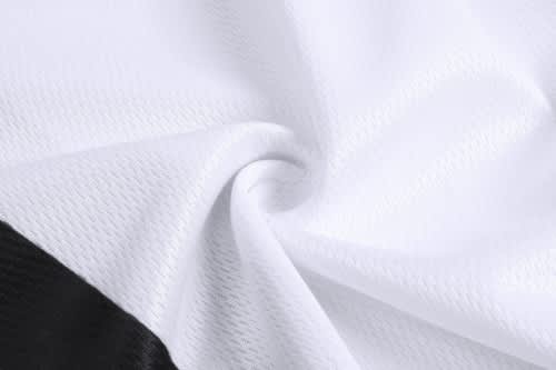 A close-up of fabric featuring a predominantly white colour with black detailing, suitable for sports jerseys.