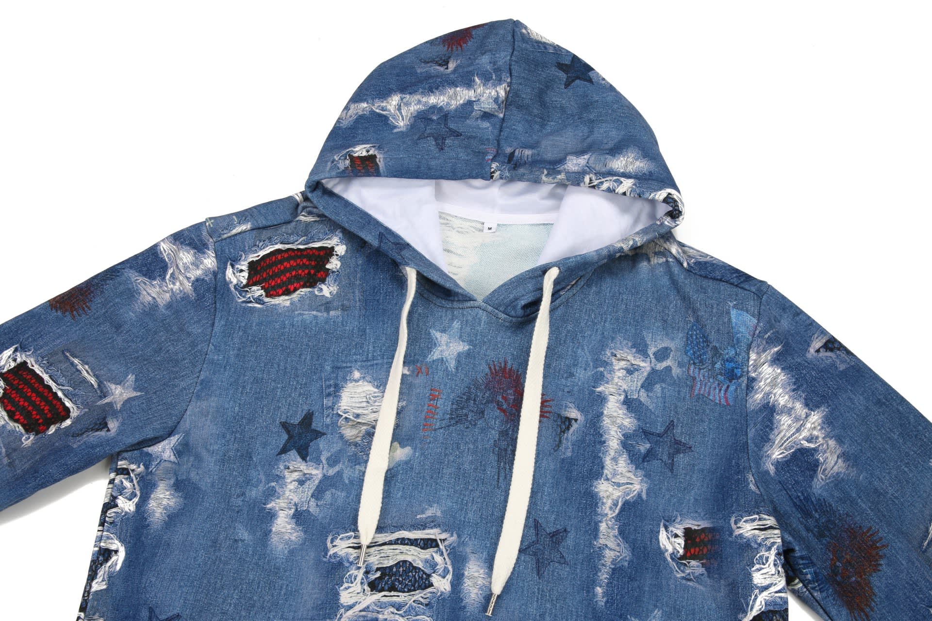 A blue denim hoodie with a distressed finish, featuring various patches and a white drawstring hood.