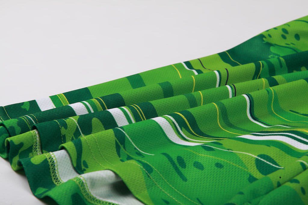 A pair of green patterned shorts with horizontal stripes and a soft fabric drape. Features branding.