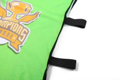A green staff bib with black edges and a logo featuring a trophy and wings. It has attachment straps on one side.