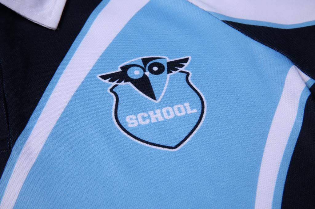 A close-up of a blue and black polo shirt featuring a logo with an owl motif and the word "SCHOOL".