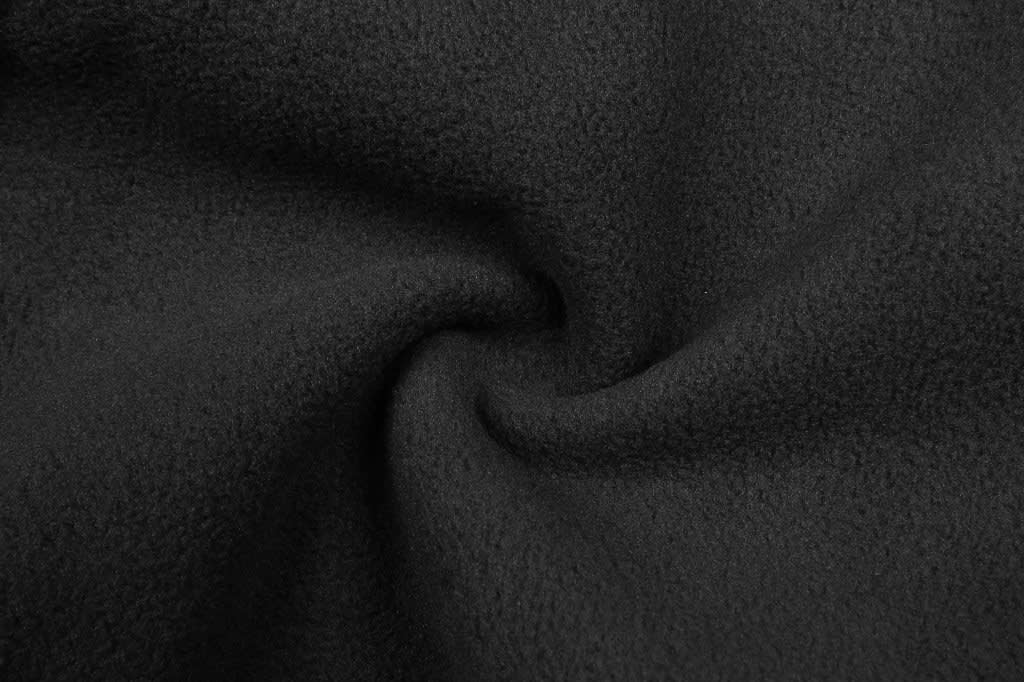 A close-up view of soft, textured black fabric featuring a swirling pattern.