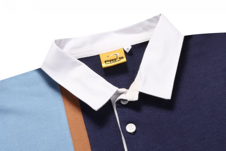 A sports jumper featuring a navy blue body, light blue sleeves, and a white collar, with a branding label.