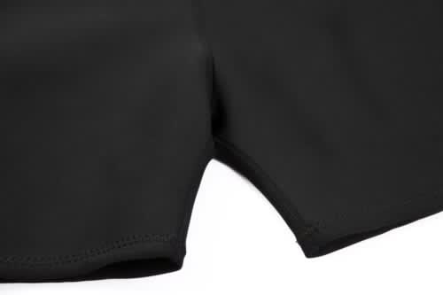 A black swimming coath designed to be anti-chlorine, featuring smooth, stitched edges. It includes a logo.