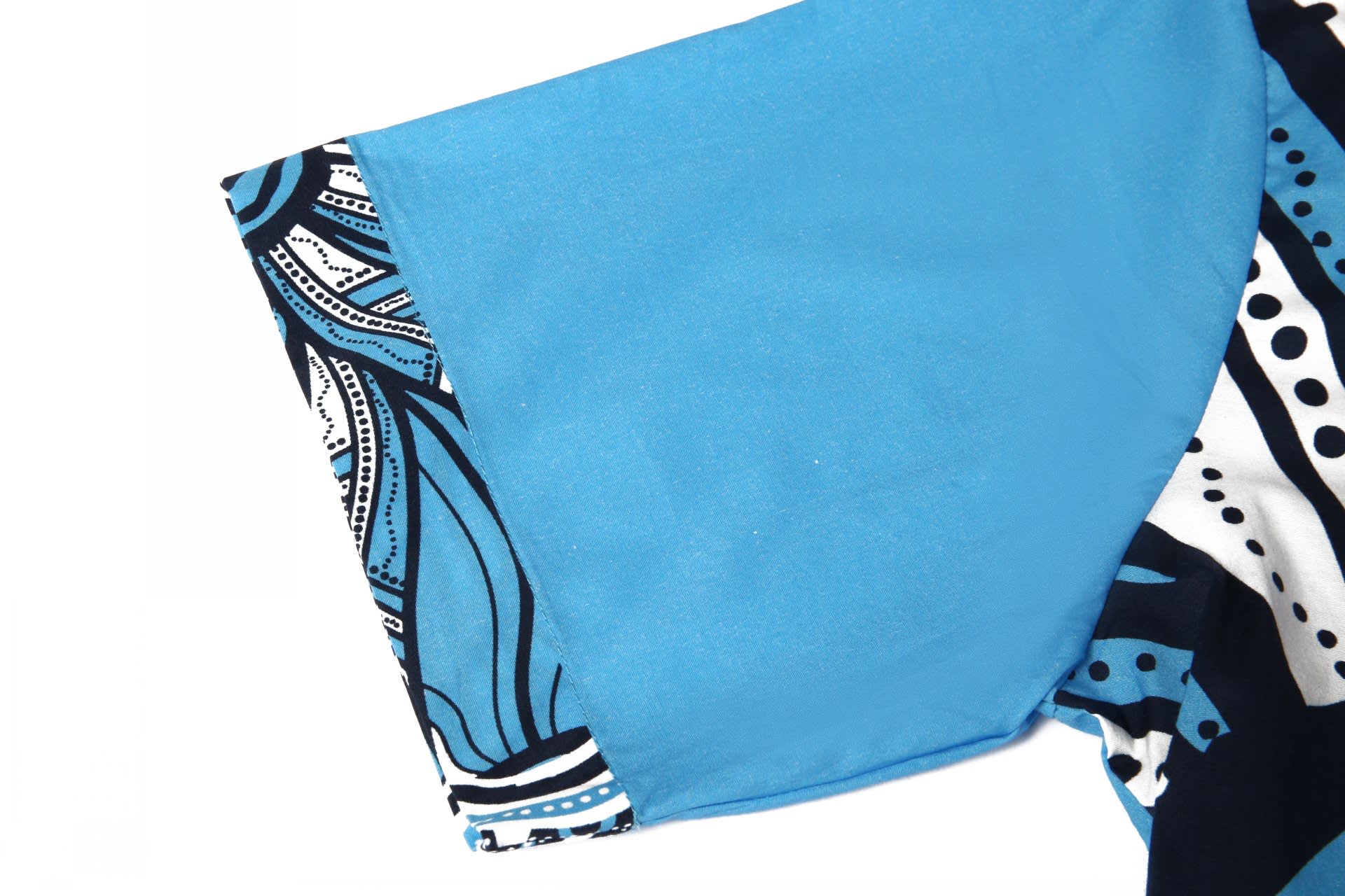 A blue cotton shirt featuring a patterned sleeve in black and white, showcasing a vibrant design.